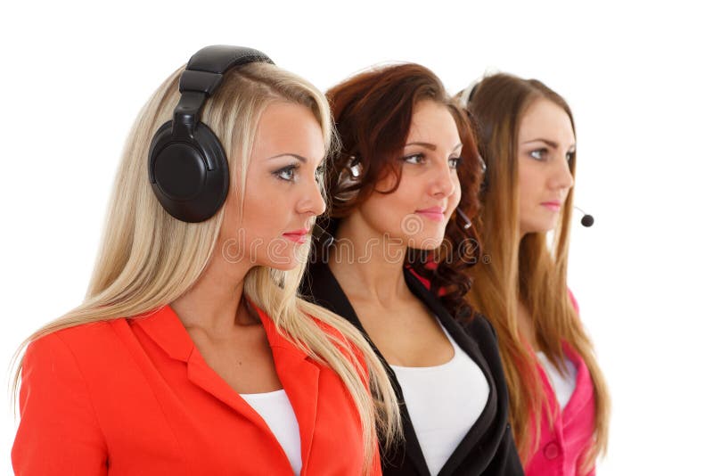 Happy young business women with headset on a white background. Operators of support service. Selective focus on first businesswoman. Happy young business women with headset on a white background. Operators of support service. Selective focus on first businesswoman.