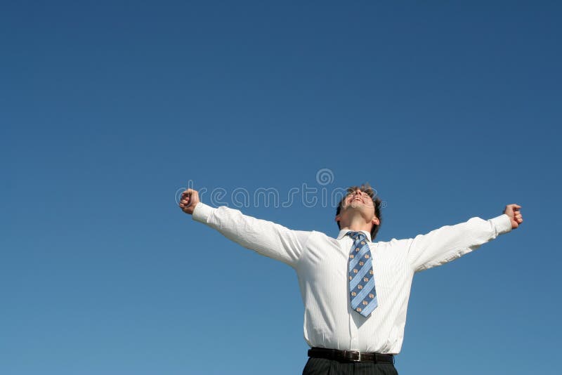 Businessman standing with arms outstretched against blue sky. Businessman standing with arms outstretched against blue sky