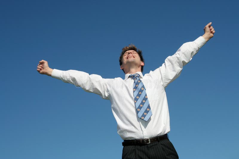 Businessman standing with arms outstretched against blue sky. Businessman standing with arms outstretched against blue sky