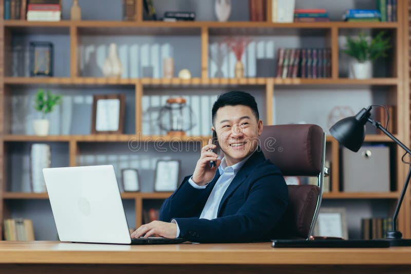 Happy businessman working in home office, smiling smiling on the phone, working on computer royalty free stock photography