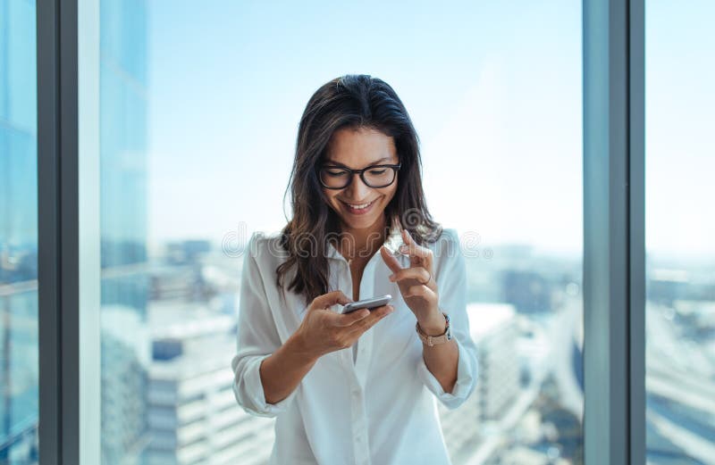 Happy Businesswoman Using Her Mobile Phone at Office. Stock Photo ...