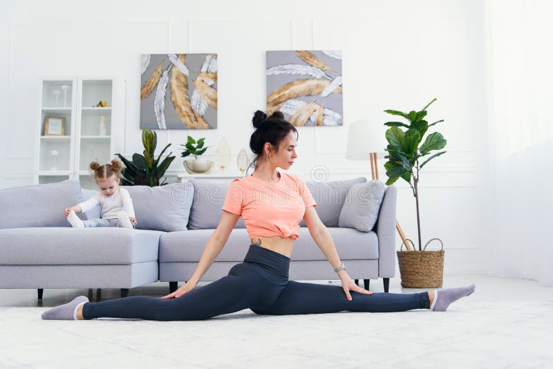 Mom on couch in yoga pants Happy Mother Doing Morning Exercises In Yoga Pose While Her Little Daughter Playing At Home Young Adorable Mom Having Stock Image Image Of Babysitter Home 187810051