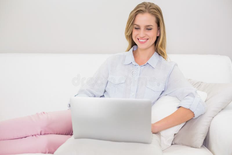 Happy Casual Blonde Relaxing on Couch Using Laptop Stock Photo - Image ...