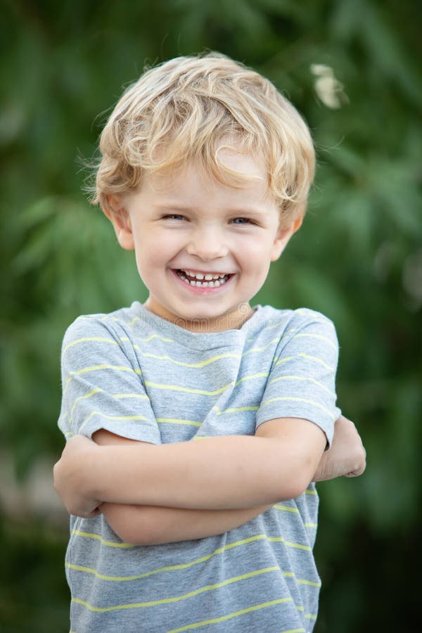 Happy child with blue t-shirt in the garden stock photography Happy child with blue t-shirt in the garden stock photography