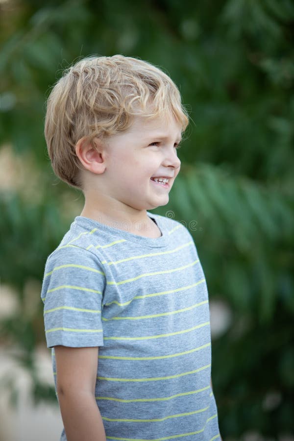 Happy child with blue t-shirt in the garden stock photo Happy child with blue t-shirt in the garden stock photo