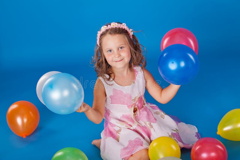 Happy child with colorful air ballons over blue