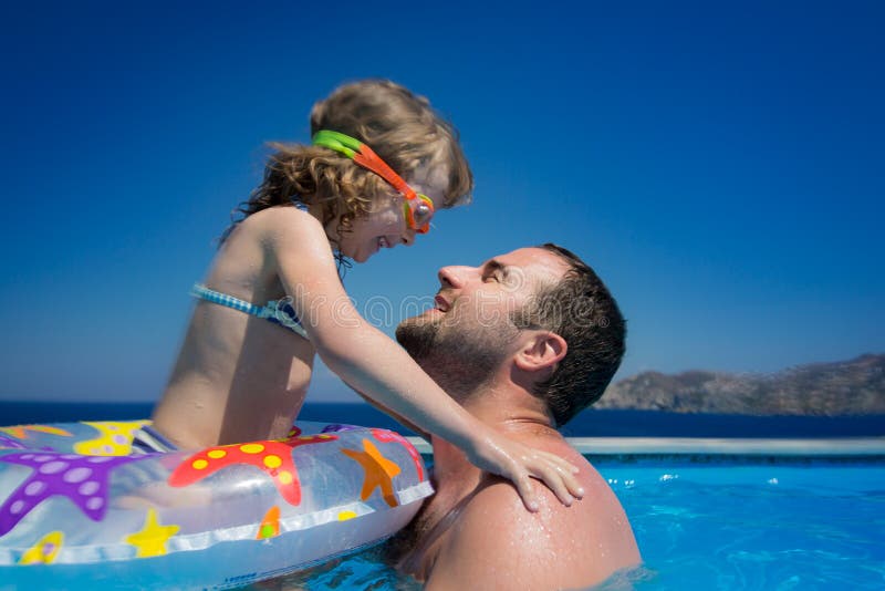 Happy child with father in swimming pool