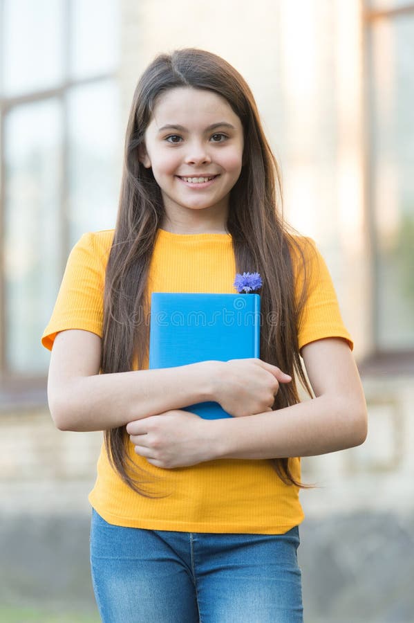 Happy child girl back to school hold textbook, september concept