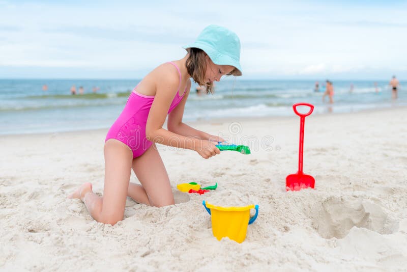 Happy child playing with sand at the beach in summer stock photography Happy child playing with sand at the beach in summer stock photography
