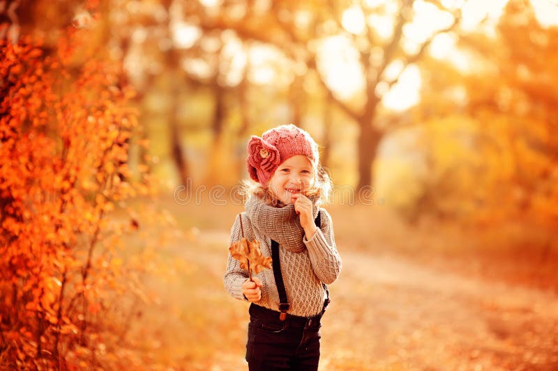 Happy child girl portrait on the walk in sunny autumn forest