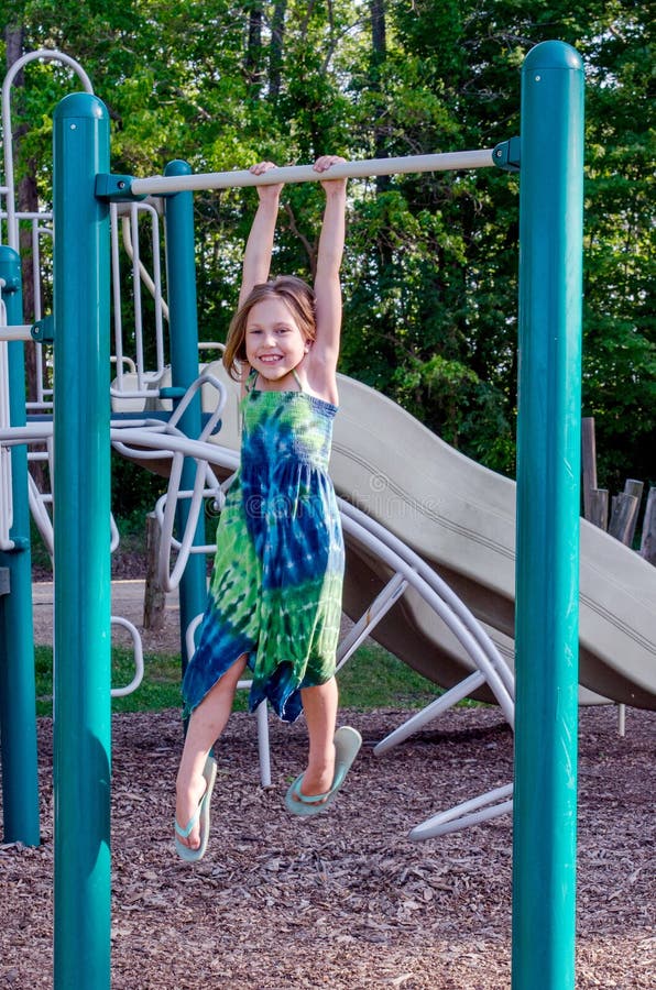 Happy child hanging from monkey bars stock images Happy child hanging from monkey bars stock images