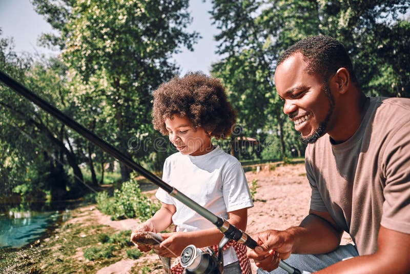 Happy Child and His Dad Fishing on Beautiful Day Outdoors Stock