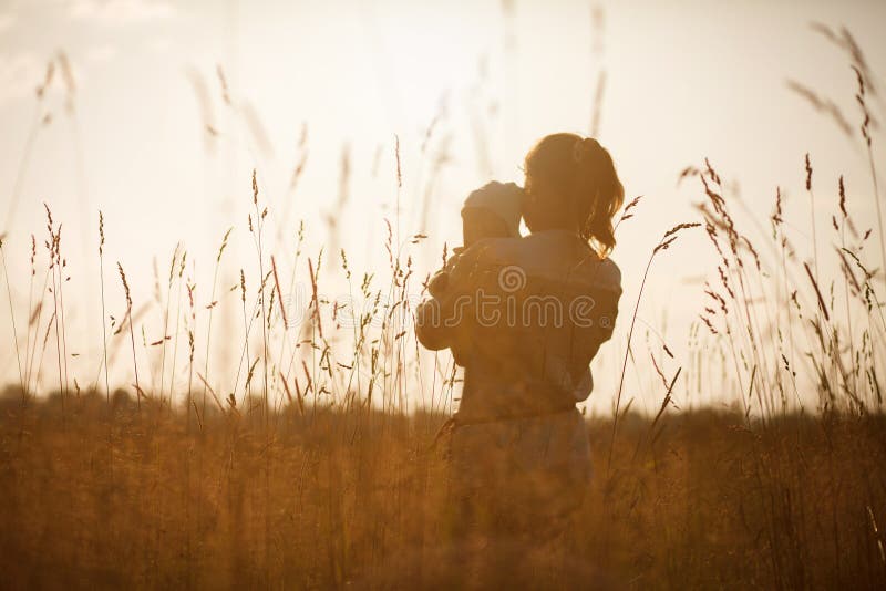 Happy child and his mom have fun outdoors in a field flooded with sunlight royalty free stock photos Happy child and his mom have fun outdoors in a field flooded with sunlight royalty free stock photos