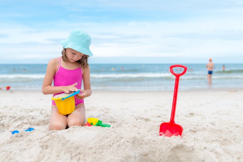 Happy child playing with sand at the beach in summer royalty free stock images Happy child playing with sand at the beach in summer royalty free stock images
