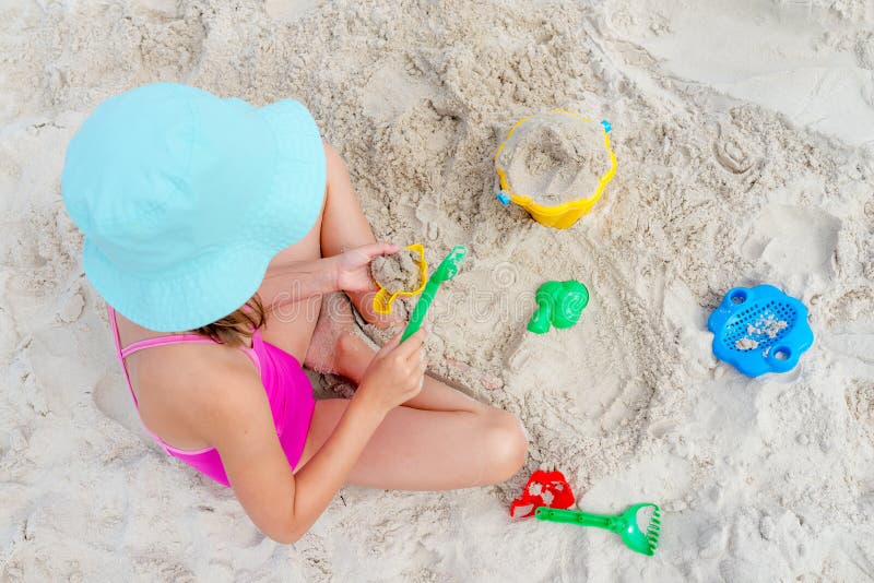 Happy child playing with sand at the beach in summer stock images Happy child playing with sand at the beach in summer stock images