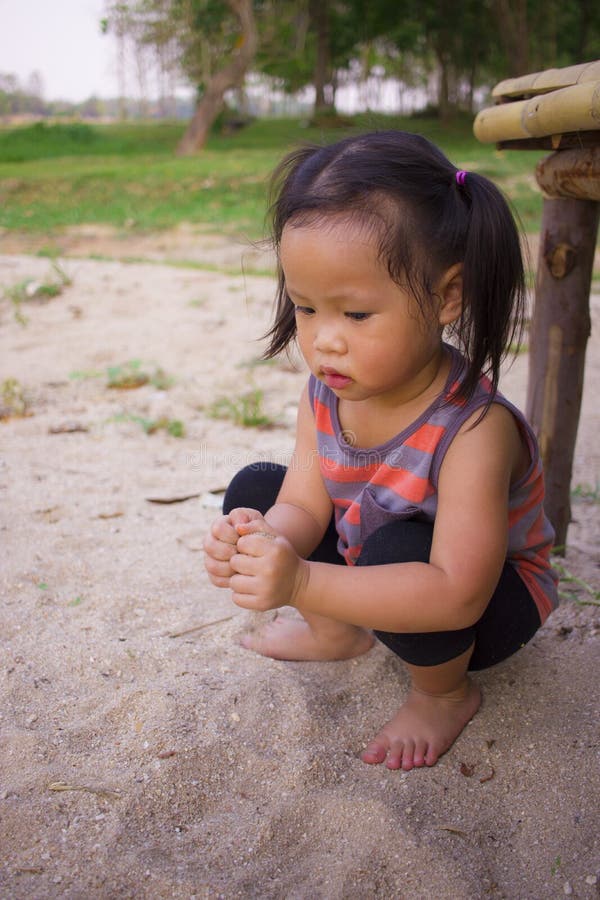 Happy child playing with sand, Funny Asian family in a park royalty free stock photography Happy child playing with sand, Funny Asian family in a park royalty free stock photography