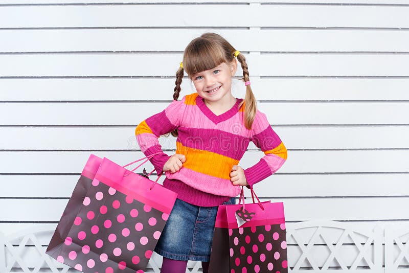 Happy child with shopping bags. She is enjoying the gifts and holidays