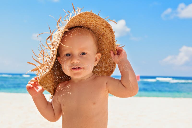 Happy child with straw had on beach on family vacation