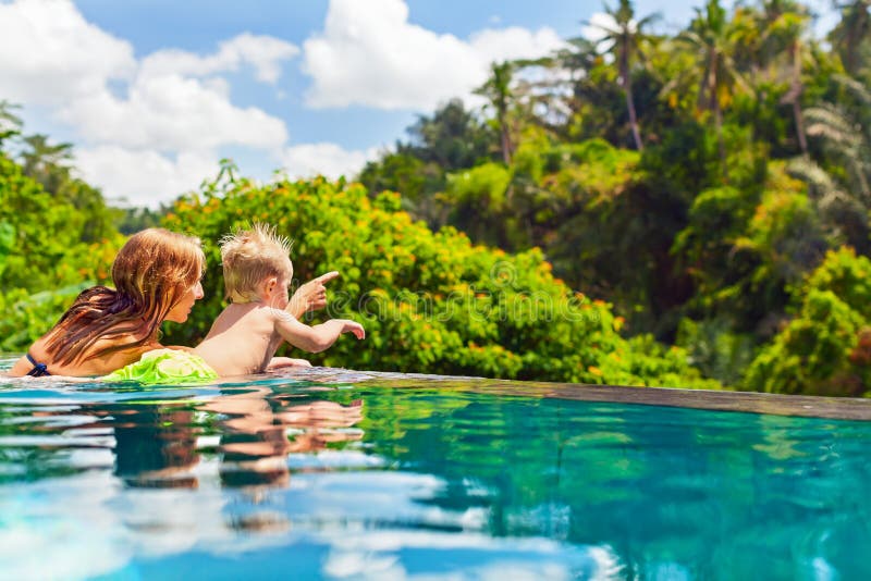 Happy child swimming in with mother infinity pool