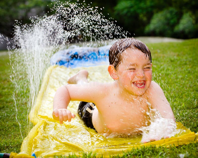 Happy child on water slide royalty free stock image