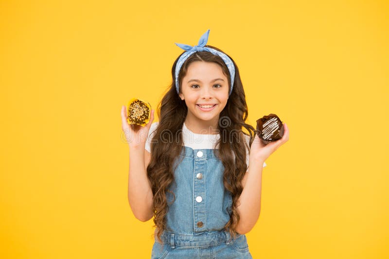 Happy childhood. Bakery confectionery concept. Kid girl hold glazed muffins. Delicious cupcakes. Adorable smiling child stock photography Happy childhood. Bakery confectionery concept. Kid girl hold glazed muffins. Delicious cupcakes. Adorable smiling child stock photography