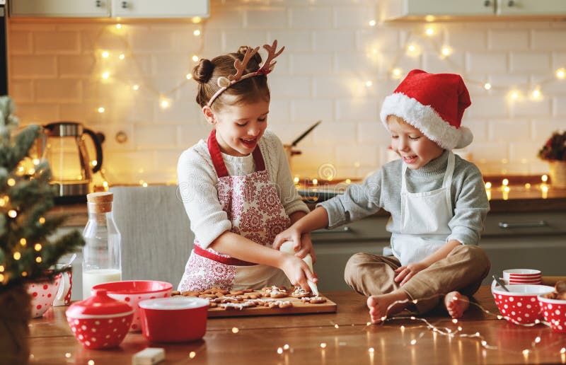 Happy children boy and girl bake christmas cookies