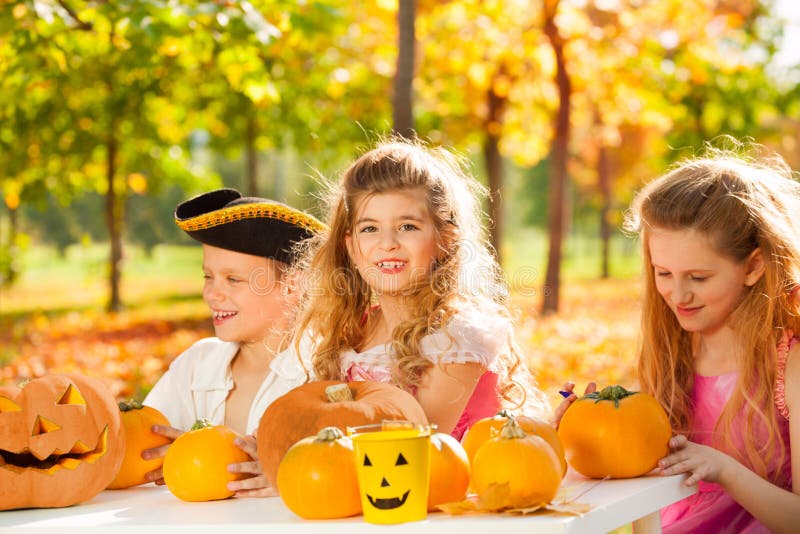Happy children in costumes craft Halloween pumpkin stock photo Happy children in costumes craft Halloween pumpkin stock photo