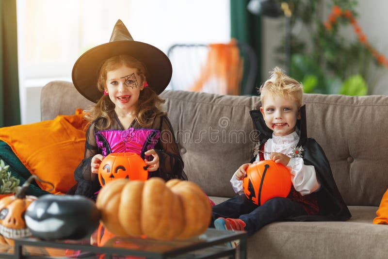 Happy children in costumes of witch and vampire are preparing
