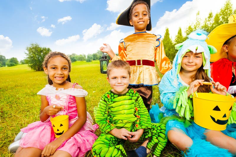 Happy Children in Halloween Costumes Sit on Grass Stock Photo - Image ...