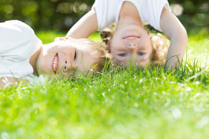 Felici i bambini che giocano sull'erba verde nel parco primavera.