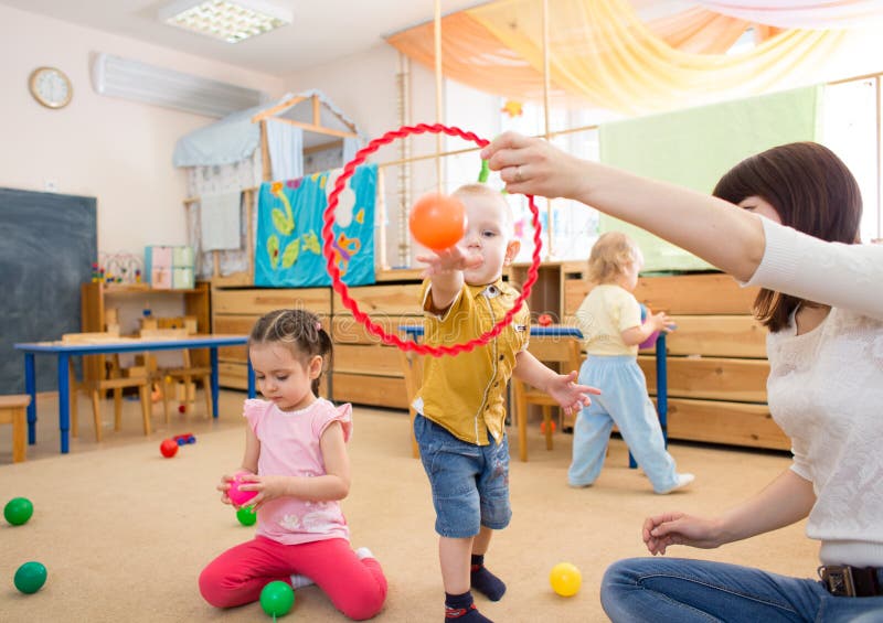 Happy children playing with ball and ring in kindergarten royalty free stock photo Happy children playing with ball and ring in kindergarten royalty free stock photo