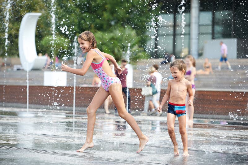 Happy children playing in a fountain