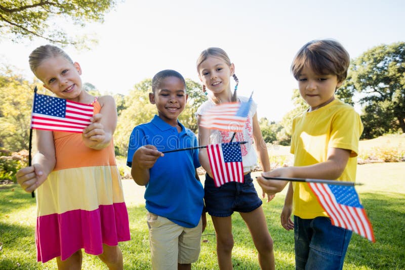 Happy children showing usa flag at park