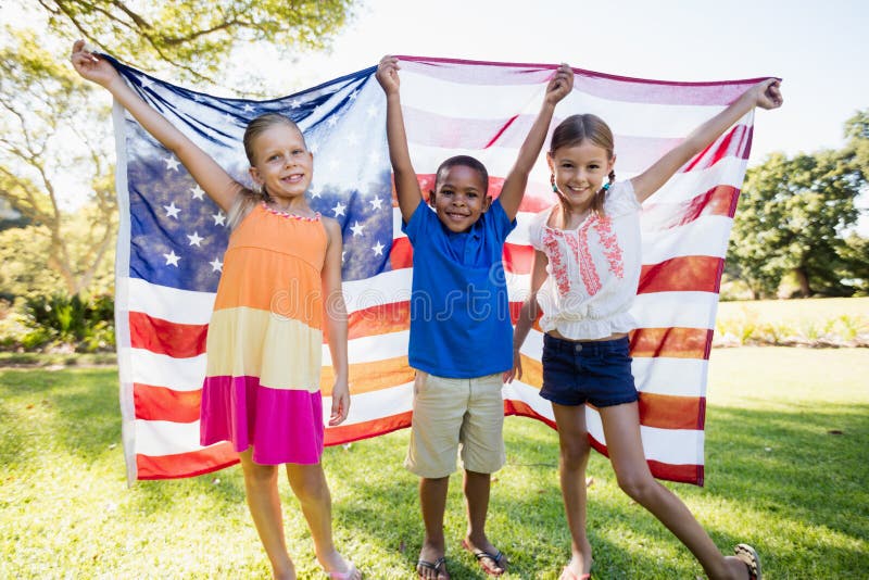 Happy children showing usa flag at park