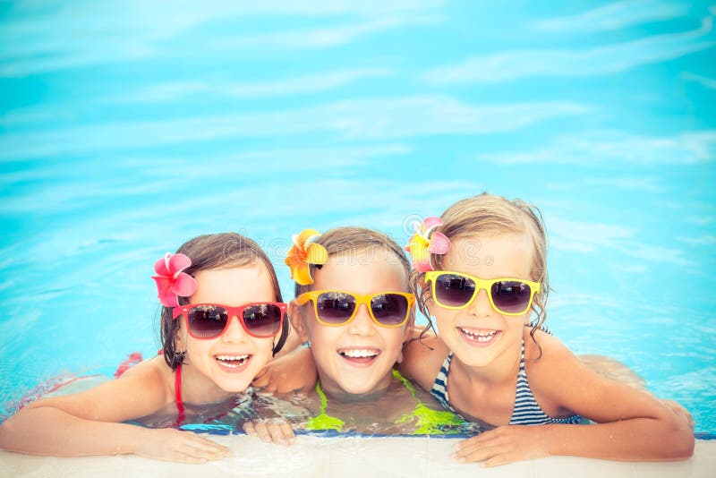 Happy children in the swimming pool. Funny kids playing outdoors. Summer vacation concept