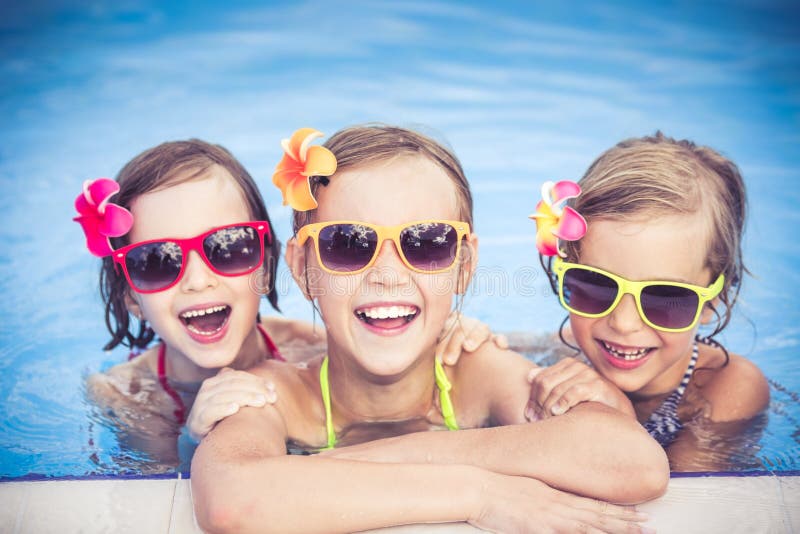 Happy children in the swimming pool. Funny kids playing outdoors. Summer vacation concept