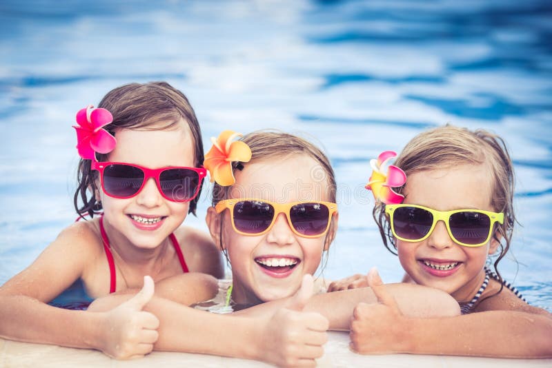 Happy children showing thumbs up in the swimming pool. Funny kids playing outdoors. Summer vacation concept. Happy children showing thumbs up in the swimming pool. Funny kids playing outdoors. Summer vacation concept