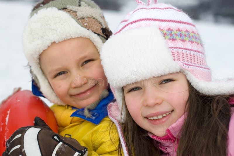 Un simpatico ragazzo e una ragazza vestita in abiti invernali, sorridenti, godendo, al di fuori al freddo.