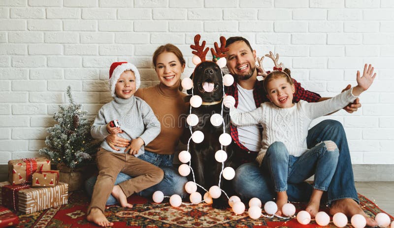 Happy Christmas! family mother father and kids with dog before Christmas with garland   and tree