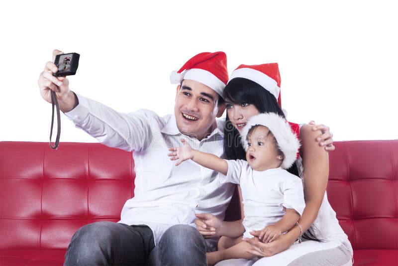 Happy christmas family take a photo sitting on red couch