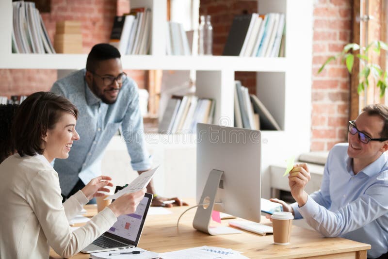 Happy collegues laugh discussing project in coworking space royalty free stock photography Happy collegues laugh discussing project in coworking space royalty free stock photography