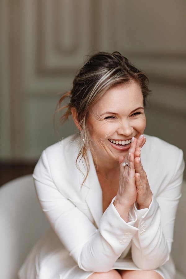 an, happy and confident woman in a white suit.