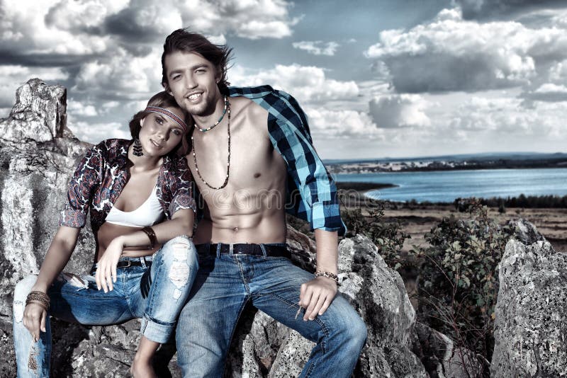 Beautiful young couple hippie posing together over picturesque landscape. Beautiful young couple hippie posing together over picturesque landscape.