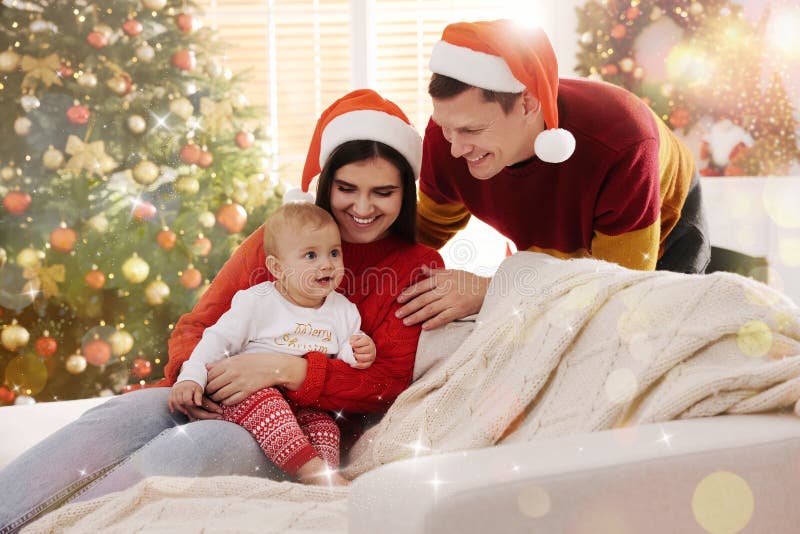Happy couple with cute baby on sofa in room decorated for Christmas. Magical festive atmosphere royalty free stock photos