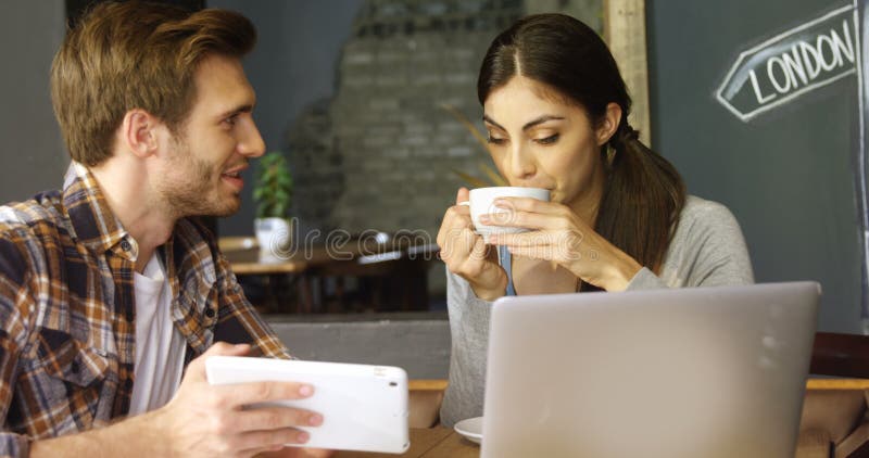 Happy couple discussing over digital tablet in cafe 4k. Hot cafe video