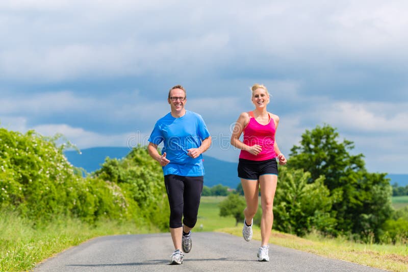 Happy couple doing sport jogging on rural street stock photo Happy couple doing sport jogging on rural street stock photo