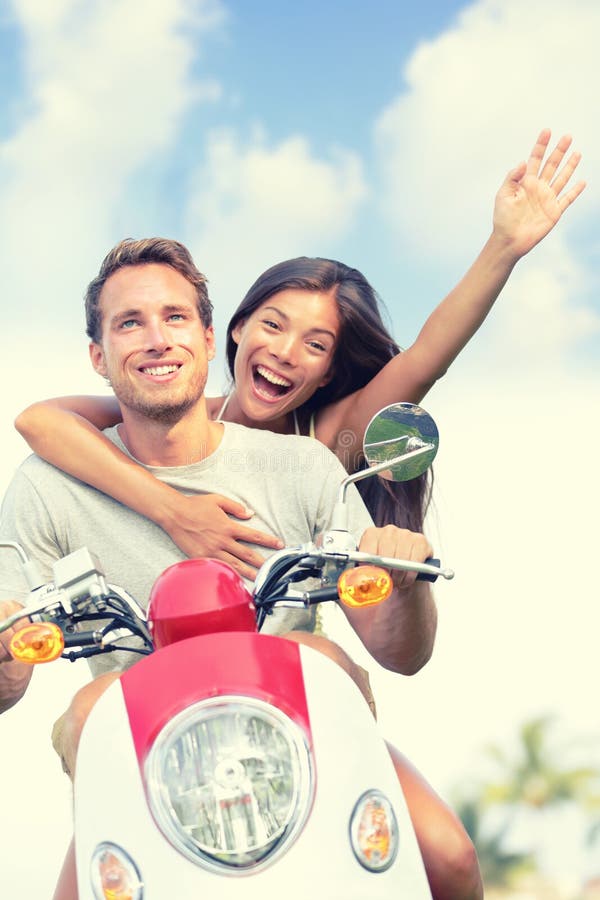 Happy Couple Enjoying Scooter Ride Against Sky