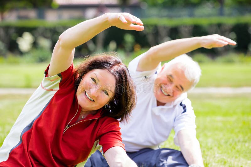 Happy Couple Exercising In Park stock image Happy Couple Exercising In Park stock image