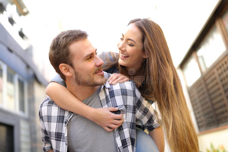 Happy couple or friends are joking in the street