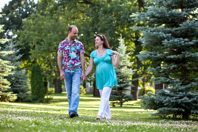 Happy couple, having joined hands walk in park